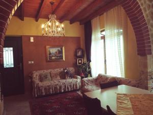 a living room with a couch and a chandelier at oniron in Sidirokastro