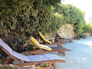 a row of lounge chairs with surfboards on them at La Gozitaine in Kerċem