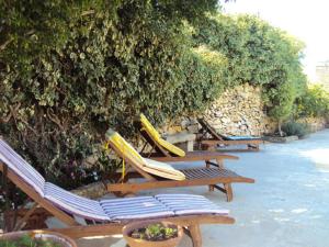 una fila de sillones con tablas de surf. en La Gozitaine en Kerċem