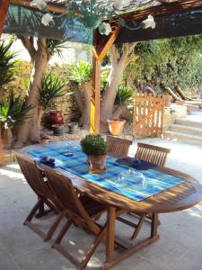a wooden table with two chairs and a blue table at La Gozitaine in Kerċem