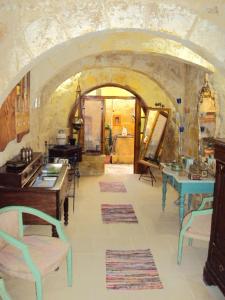 a kitchen with an archway with tables and chairs at La Gozitaine in Kerċem