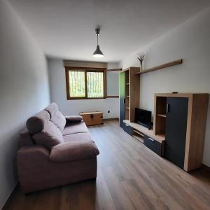 a living room with a couch and a tv at El Tranco Apartamentos in Villel