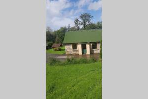 a house with a green roof in a field at Cottage ideal for Family's & private lake access in Leitrim