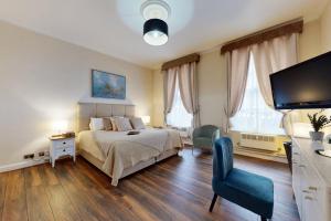 a bedroom with a bed and a flat screen tv at Park Lane Apartments/Shaw House in London