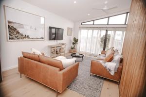 a living room with two couches and a tv at Ocean Oasis Port Campbell in Port Campbell