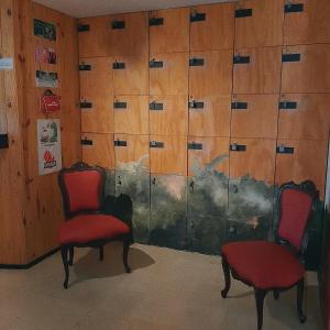 dwa czerwone krzesła przed szklanymi drzwiami w obiekcie Cloud9 Hostel w mieście Medellín