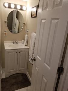 a white bathroom with a sink and a mirror at The Airport Lodge in Collingdale