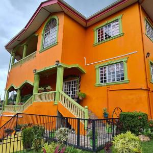 ein orangefarbenes Haus mit einer Veranda und einem Balkon in der Unterkunft Mountain Palace in Guarata