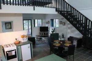 a kitchen and living room with a staircase at GREEN TREES CHALET 10 minutes to Australia Zoo Landsborough Montville Maleny Caloundra Beaches Glasshouse mountains Big Kart Track National forest in Landsborough