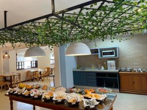 a kitchen with a table with food on it at Pousada Finlândia in Penedo