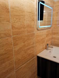 ein Bad mit einem Waschbecken und einem Spiegel in der Unterkunft Charmant T3 climatisé Piscine privée in Le Diamant