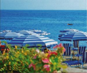a group of blue and white umbrellas on a beach at Hotel Santa Rosa Centro Vacanze in Sangineto