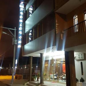 un bâtiment avec un panneau sur son côté la nuit dans l'établissement Hotel Premier Inn, à Manta