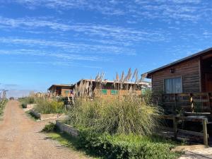 a dirt road in front of wooden buildings at Cabañas y Centro Eventos Leyda in San Antonio