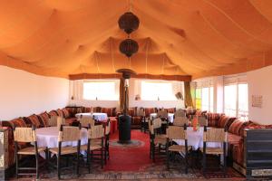 un comedor con mesas y sillas y una tienda grande en Luxury Berber Camp, en El Gouera 64 fotos más