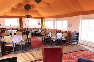 a restaurant with tables and chairs in a room at Luxury Berber Camp in El Gouera
