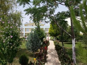 a garden with trees and flowers in front of a building at Melodi Club Apart in Davutlar