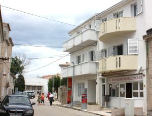 un edificio en una calle con gente caminando por la calle en Apartments Center Pag 50 m to the sea, en Pag