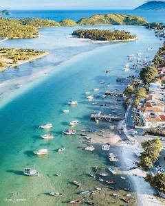 uma vista aérea de uma praia com barcos na água em Apês do Peró - Centro - suíte 03 em Cabo Frio