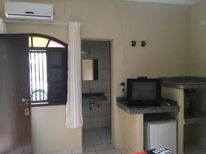 a bathroom with a television and a bathroom with a sink at Residencial Beira Mar Cananéia in Cananéia