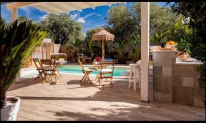 eine Terrasse mit einem Tisch und Stühlen neben einem Pool in der Unterkunft L'Oasi Di Franco in Villa San Pietro