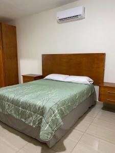 ein Schlafzimmer mit einem Bett und einer Klimaanlage an der Wand in der Unterkunft CMG Suites in Ciudad Acuña