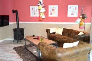 Dreamhus Wyk في فيك أوف فور: غرفة معيشة مع أريكة وموقد خشبي