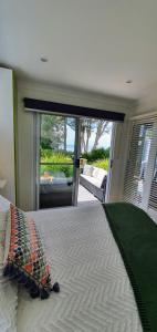 a bedroom with a bed with a view of a patio at Goat Island Bungalow in Ulverstone