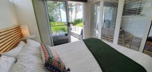 a bedroom with a bed and a large window at Goat Island Bungalow in Ulverstone