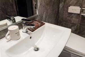 a bathroom with a white sink and a mirror at Hotel Marcher in Busan