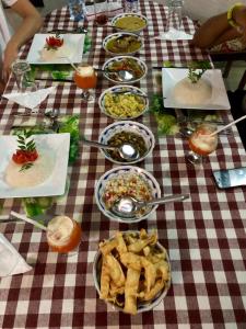 a table with plates of food on a checkered table cloth at Sigiri Anu Homestay in Sigiriya