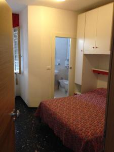 a room with a bed and a bathroom with a toilet at Hotel Villa Ginevra in Cavallino-Treporti