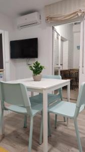 una mesa blanca y sillas con una maceta. en Guimar New Style, tu nueva elección, en Córdoba