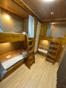 a room with three bunk beds in a cabin at ゲストハウス喜舎場 in Ishigaki Island