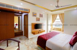 a bedroom with a bed and a flat screen tv at Moois Residency in Kannur