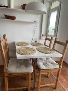 un tavolo con quattro piatti sopra con quattro sedie di Vier Jahreszeiten 4JZ Haus 4 Whg 14 a Grossenbrode