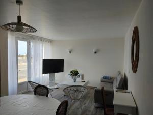 a living room with a couch and a table at Au repos des baigneurs, appartement rez-de-chaussée, WIFI in Le Tréport