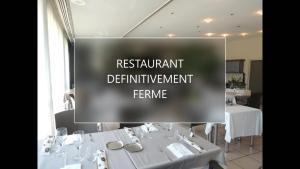 un panneau indiquant un restaurant avec des tables et des chaises blanches dans l'établissement Hôtel 4C, à Cluses