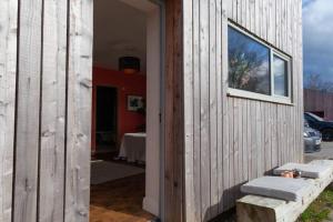 a wooden house with a window on the side of it at "The Studio" Contemporary studio with organic swimming pool in Skelsmergh