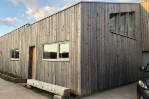 a wooden house with a bench in front of it at "The Studio" Contemporary studio with organic swimming pool in Skelsmergh