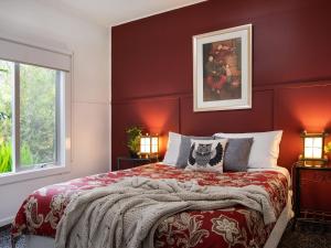 a bedroom with a large bed with red walls at The Apple Tree in Hepburn Springs