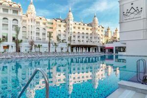 une grande piscine en face d'un bâtiment dans l'établissement Side Royal Style Hotel, à Sidé