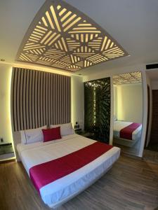 um quarto com uma cama grande e um cobertor vermelho em Amarterra Hotel Boutique em Cidade do México