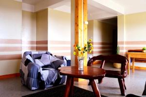 a living room with a table and a chair at Wanay's Rocky Mountain Homestay in Baguio