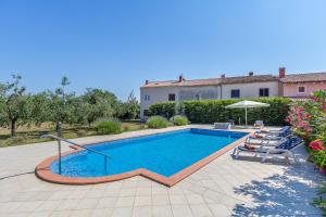 a swimming pool in a yard with a house at Pool & Sun Villa Rici in Loborika