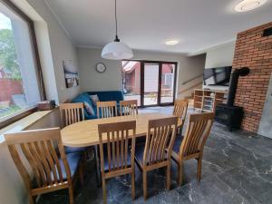 jadalnia i salon ze stołem i krzesłami w obiekcie Willa Słoneczna w Sztutowie