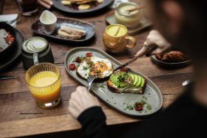 a person sitting at a table with a plate of food at Stories Boutique Hotel in Budapest