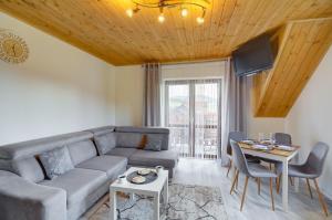 uma sala de estar com um sofá e uma mesa em Apartamenty Szwarcowa em Tylicz