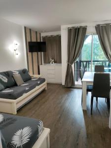 een woonkamer met een bed en een eetkamer bij Appartement - Résidence du golf deauville 2 in Deauville