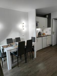 een keuken en eetkamer met een witte tafel en stoelen bij Appartement - Résidence du golf deauville 2 in Deauville